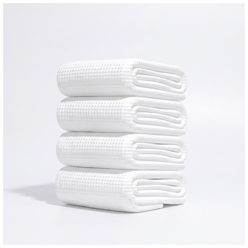 Stack of folded disposable white waffle-texture towels